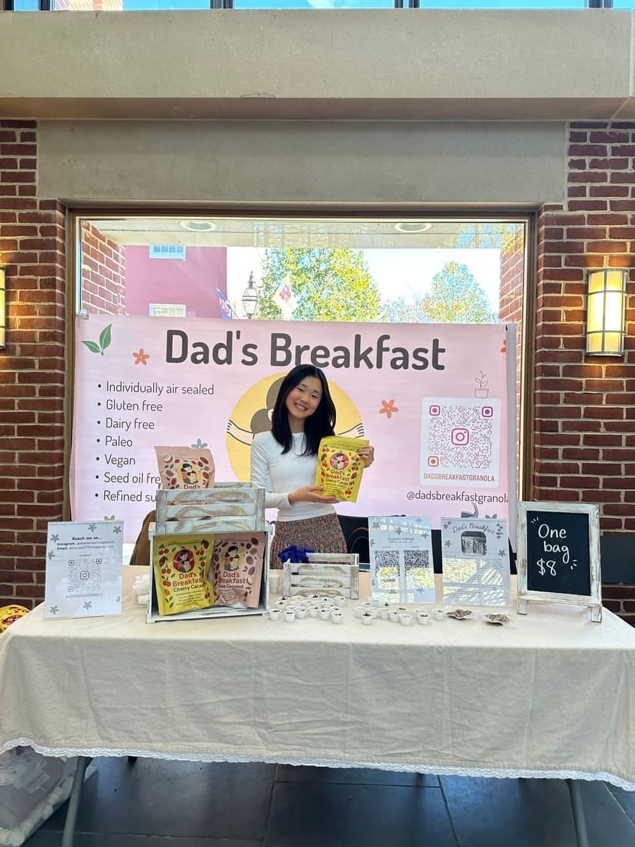 Founder of Dad's Breakfast at her booth with the brand banner